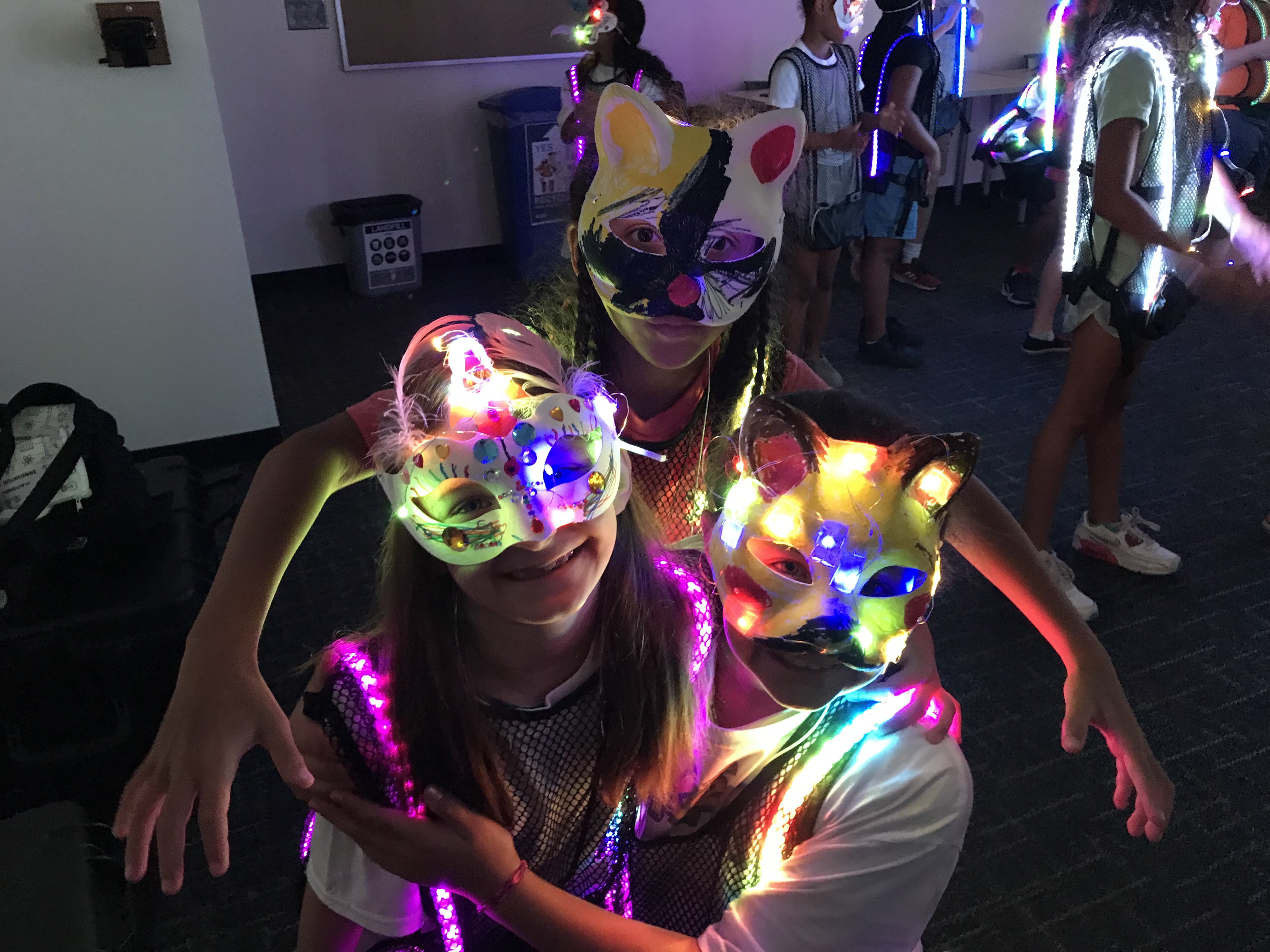Kids dancing in glowing LED STEMasks and iLuma vests